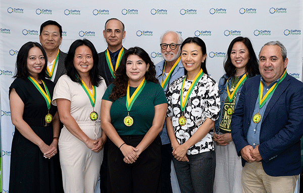 One Team Award Winners who worked on Roots House pose with their medals.
