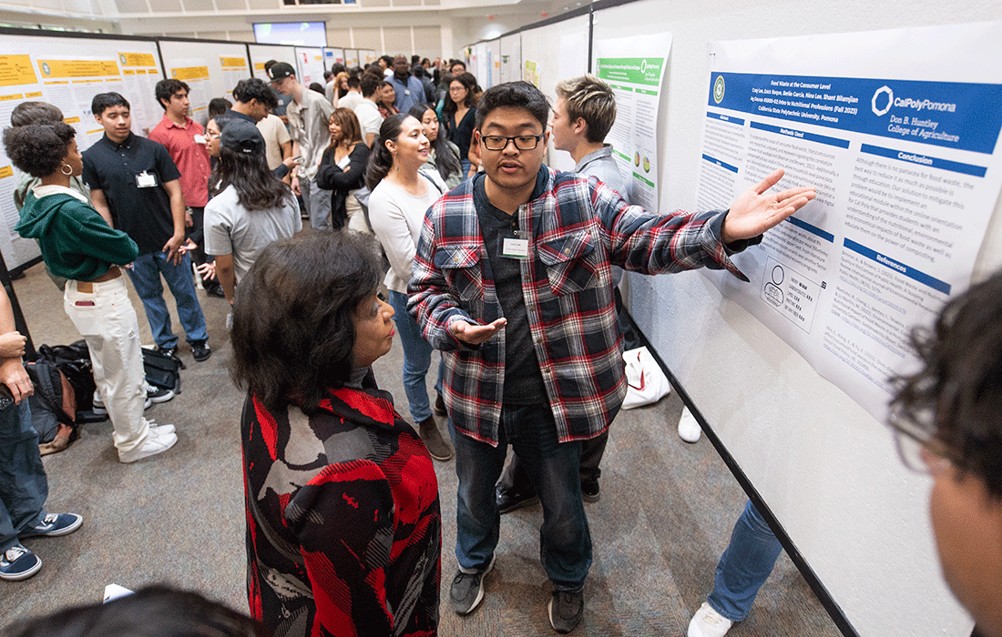 A male student presents his research to President Coley.