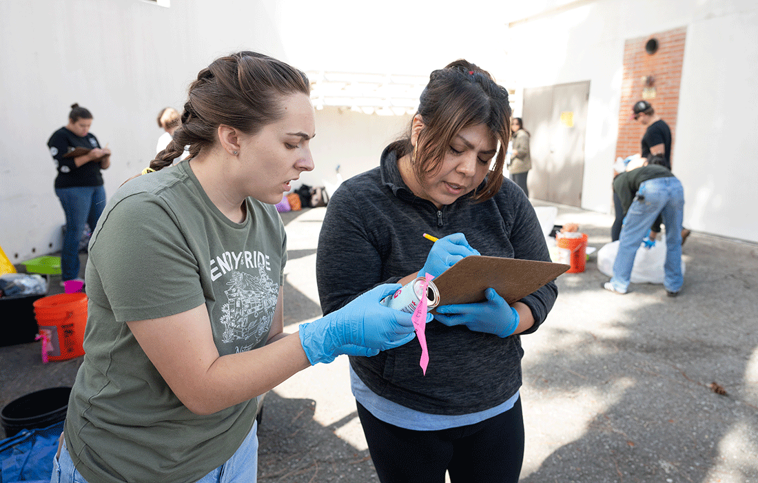 Amelia Bellah, left, and Sharon Figueroa inspect an artifact during trash excavation in Assistant Professor Annie Danis' anthropology class.
