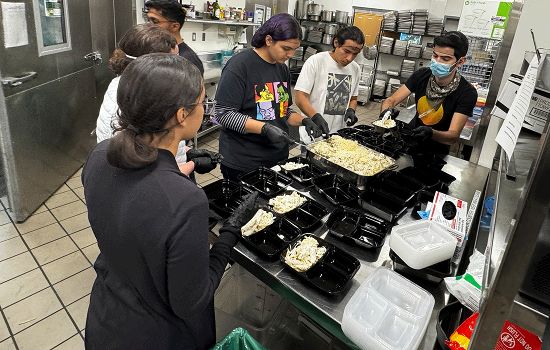Faheem and volunteers in Centerpointe's kitchen.