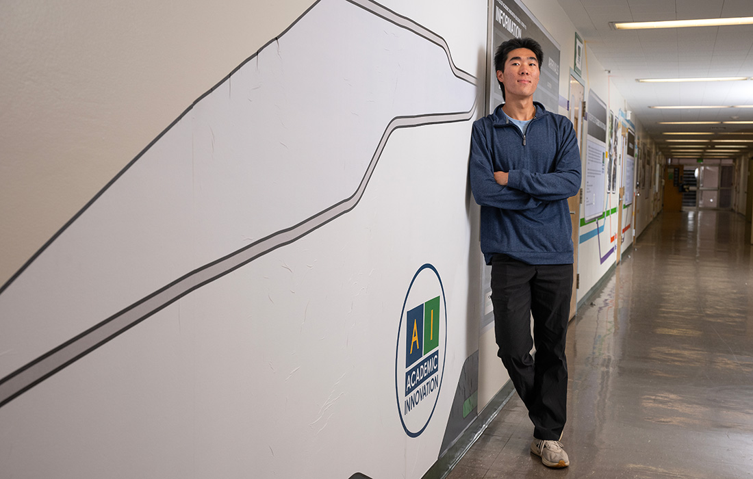 male student poses in front of the Office of Academic Innovation on campus.