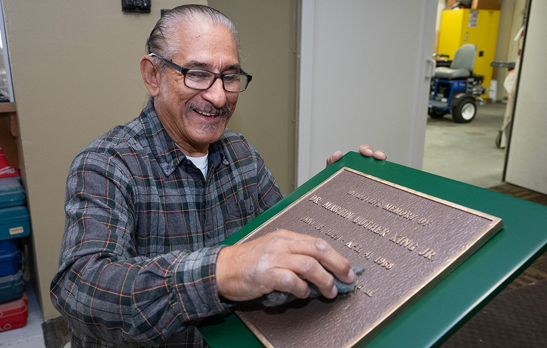 landscape services employee works on the MLK Jr. Plaque