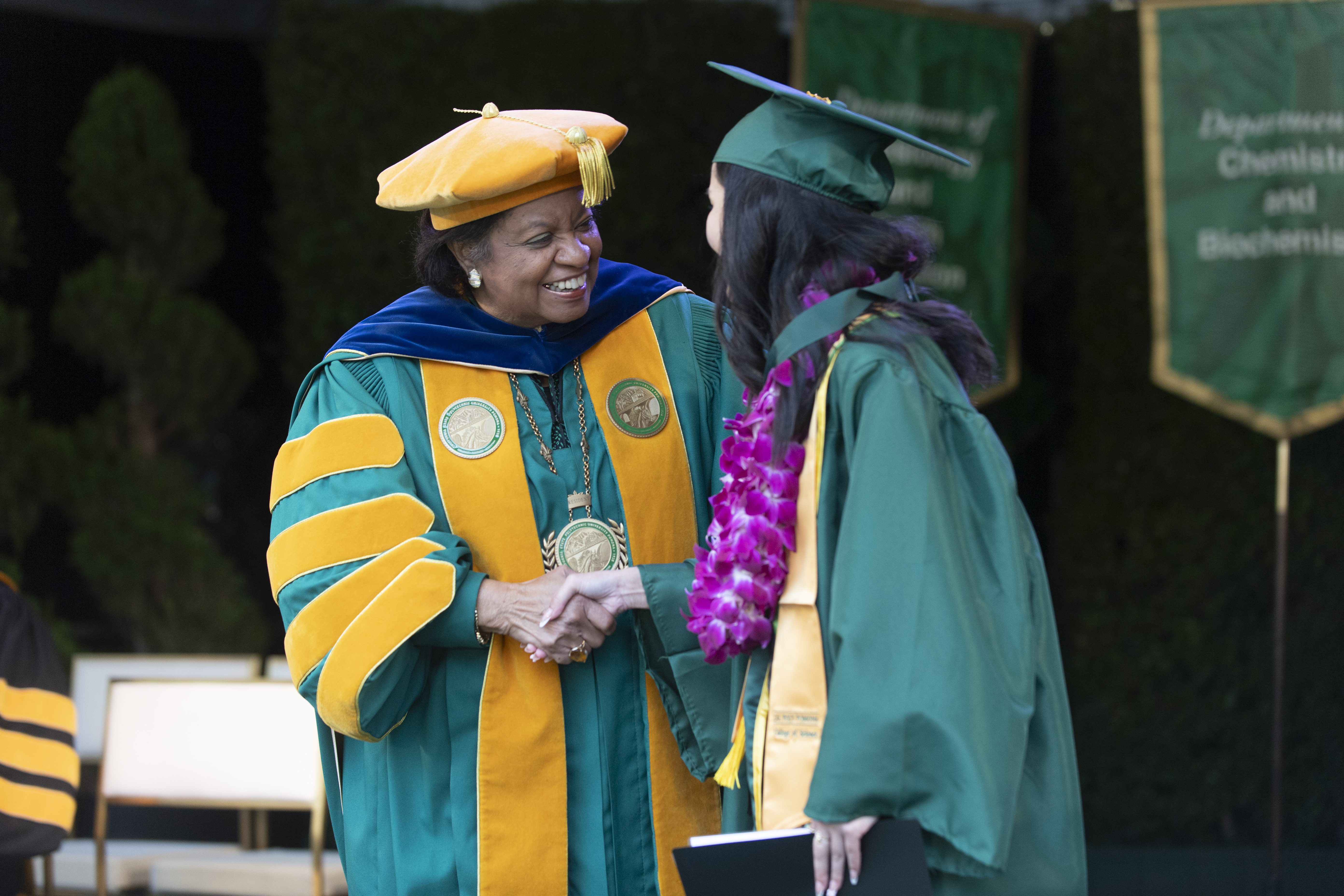 President Coley shakes a female graduates hand.