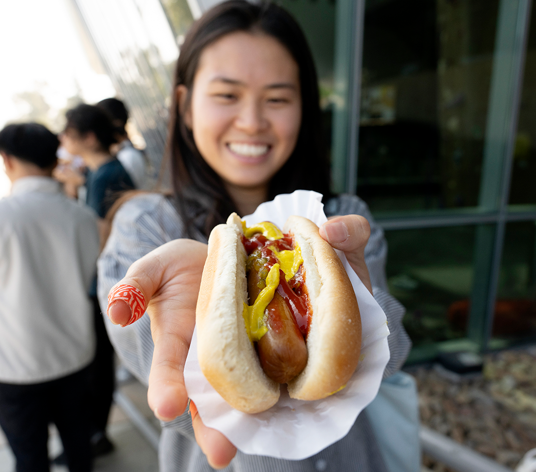 A female student holds her hot dog