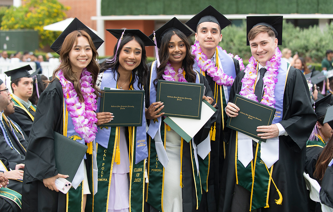 A group of graduates hold their diplomas during 
