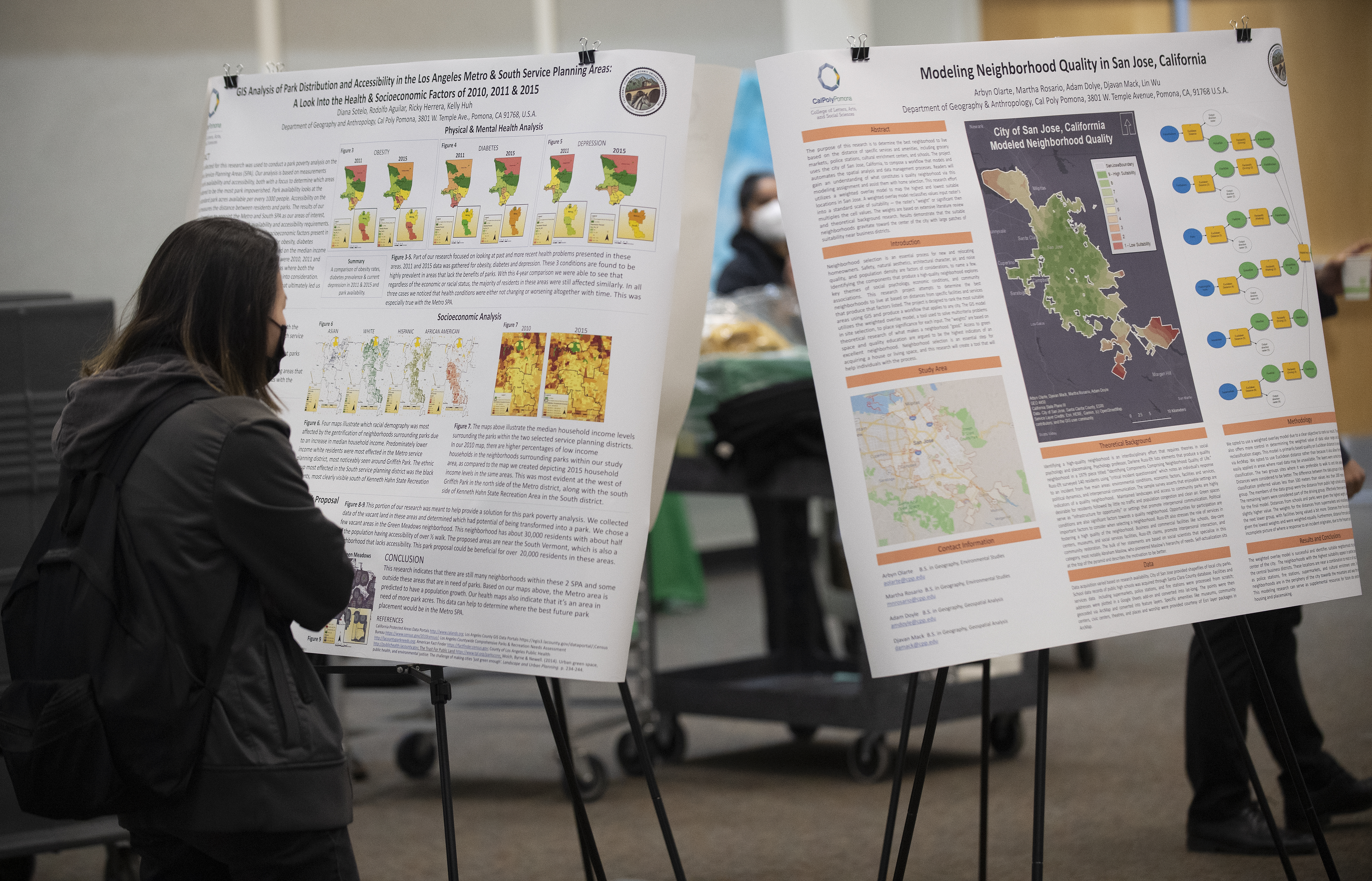 Female student looks at a research poster during GIS Day 2023. 