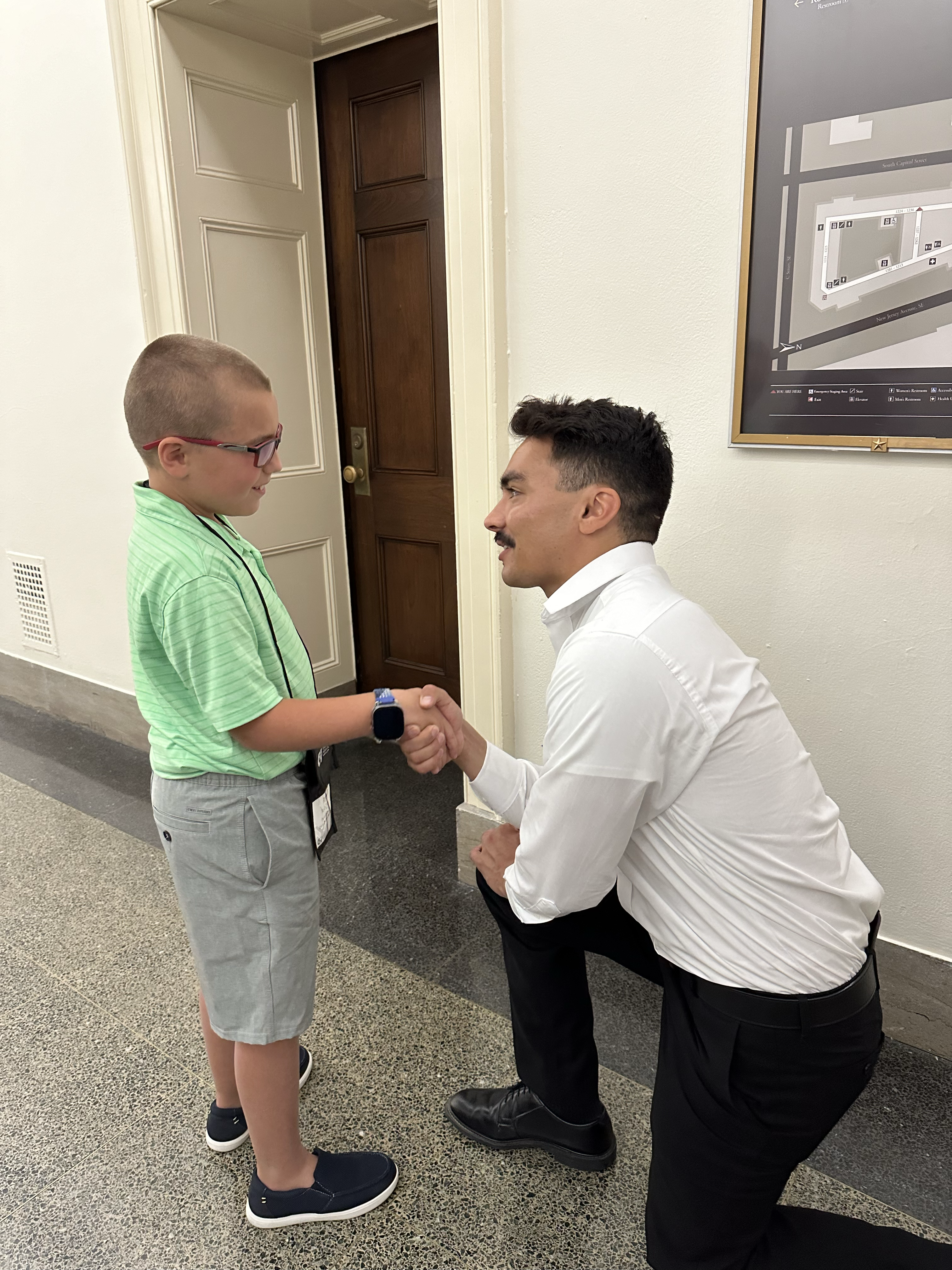 Michael Miser shakes hands with a child. 
