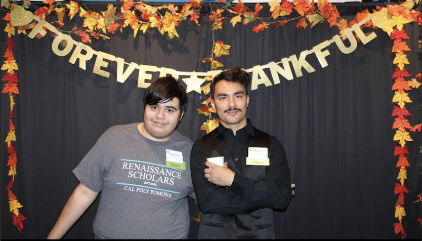 Michael Miser poses with a friend under a Thankful sign.