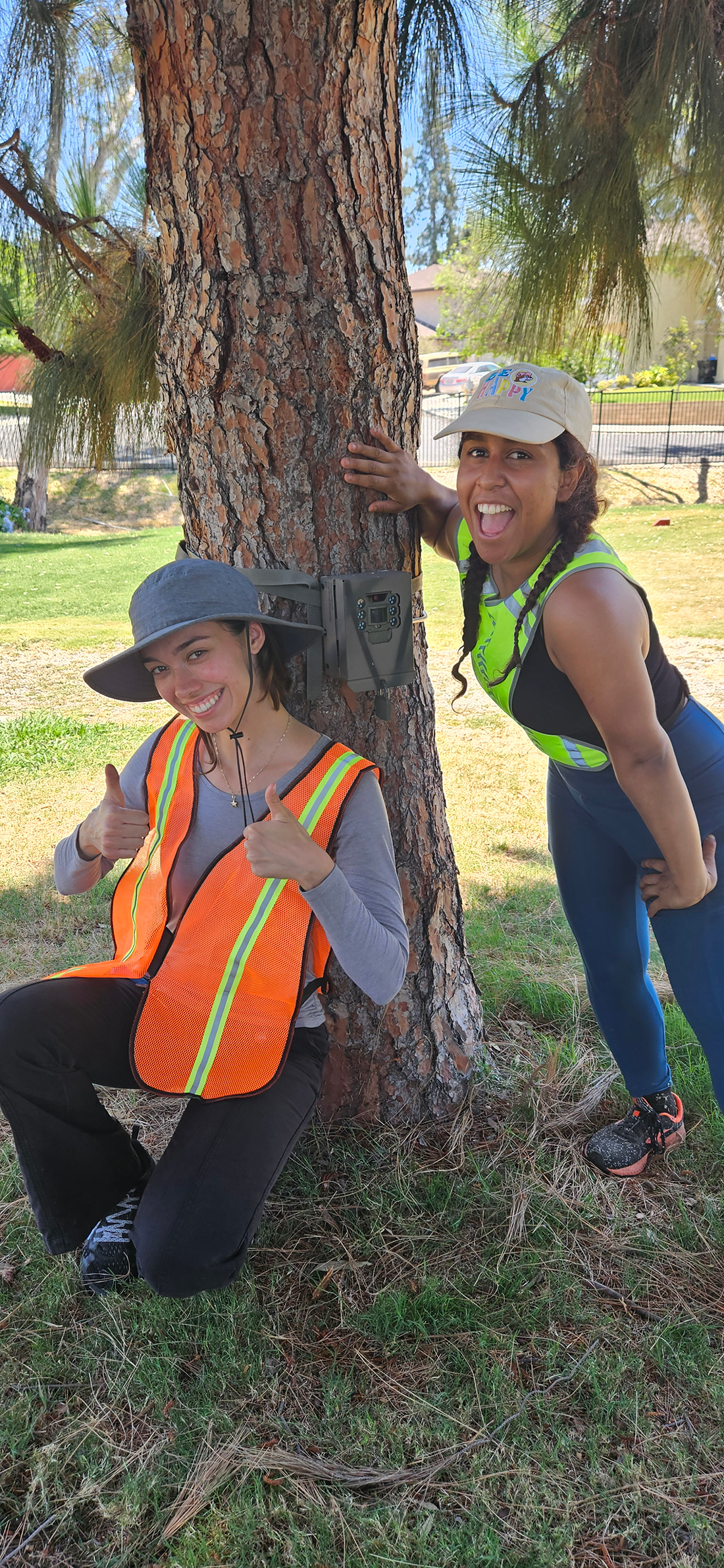 Two students smile as they set up a camera.