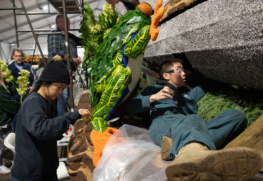 Two CPP students decorate the exterior of the float.