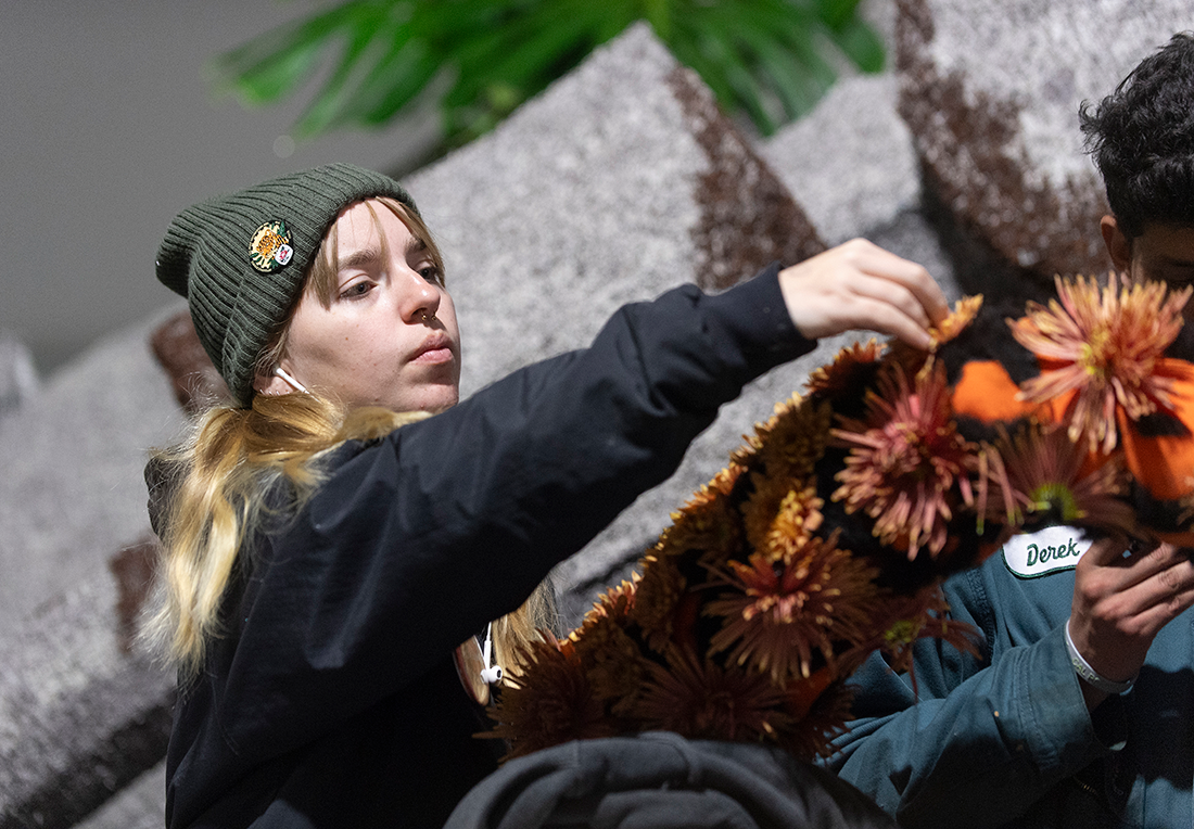 female cpp student adds flowers to the float.