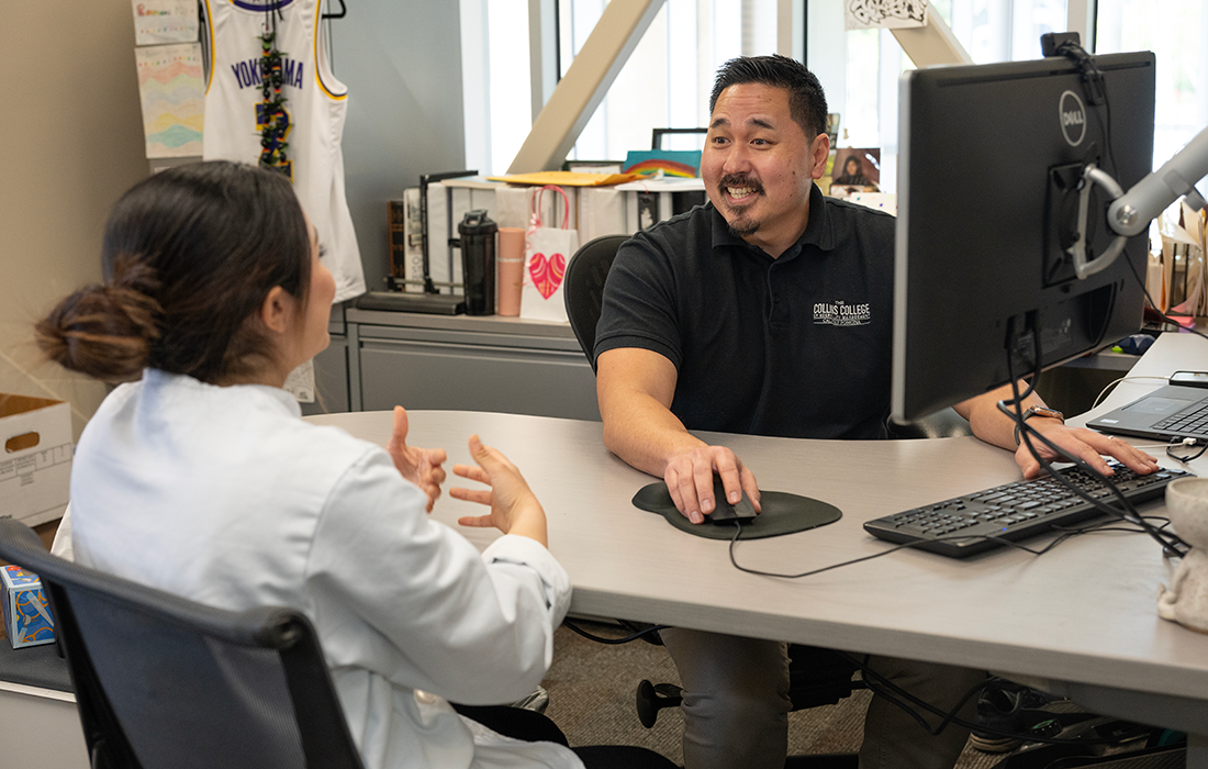 A Collins College advisor speaks with a student in his office.