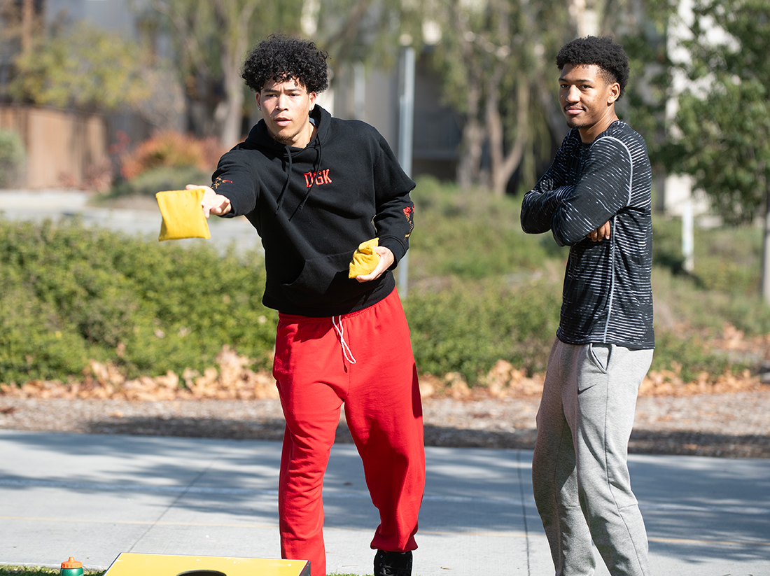 Two male students play on the lawn.