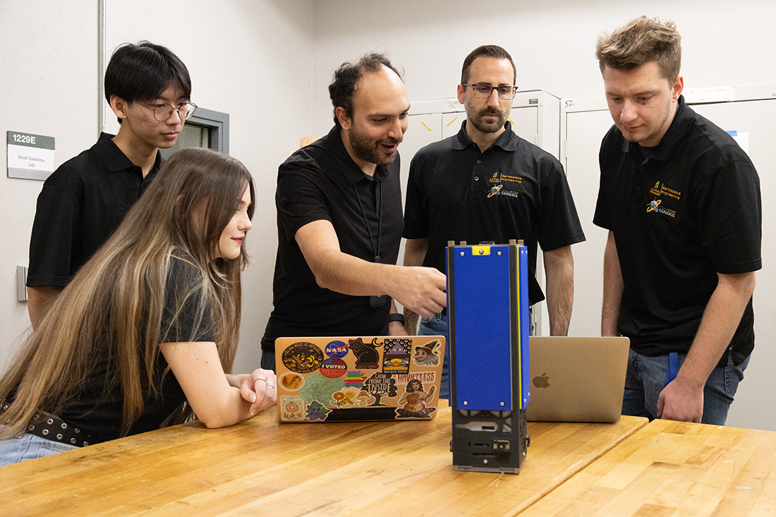 Professor Nakhjiri and students with the CubeSat