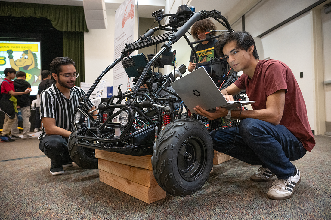 A group of students work on an automomous vechcle. 