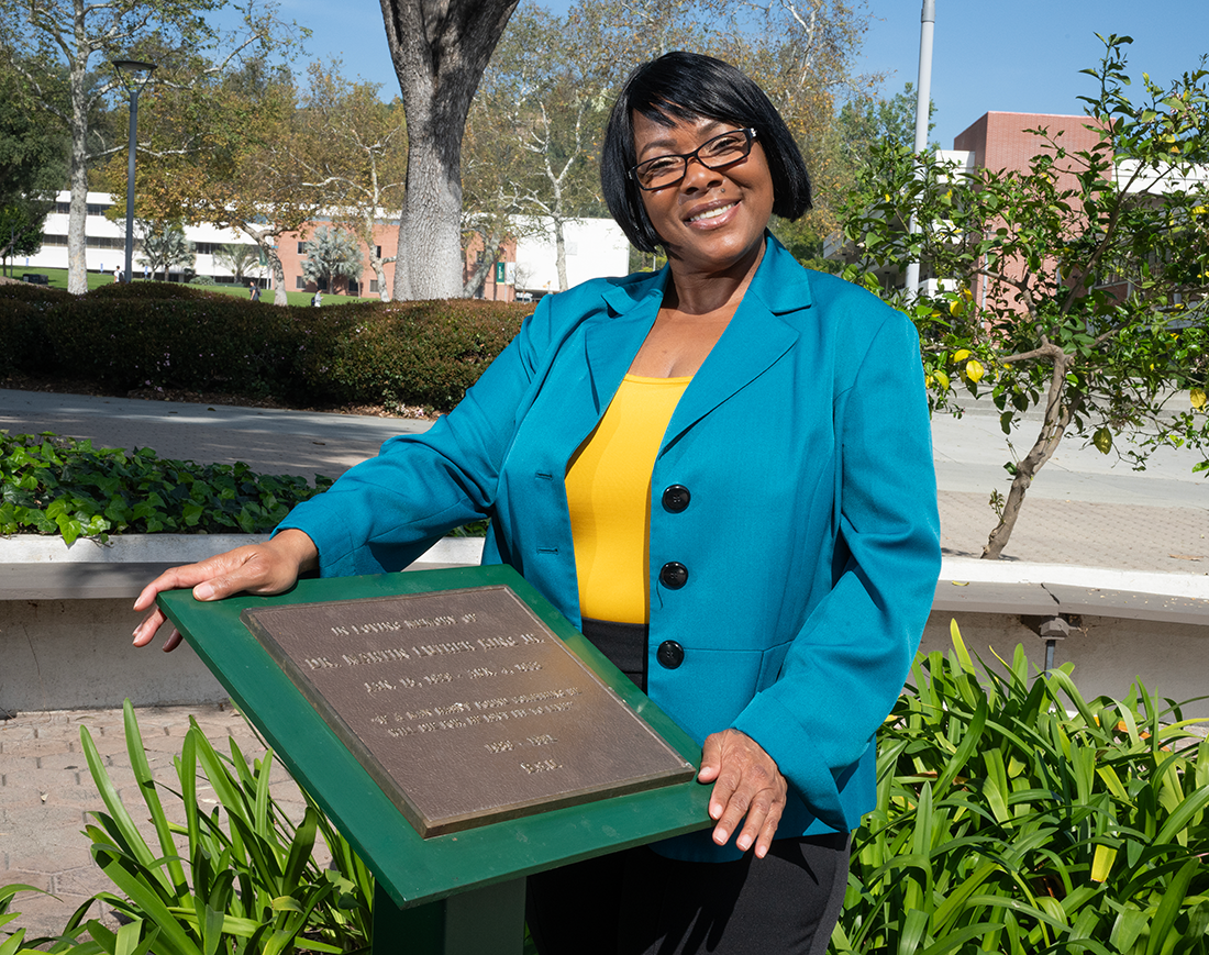 Devoneia Jordan with the MLK plaque on campus. 