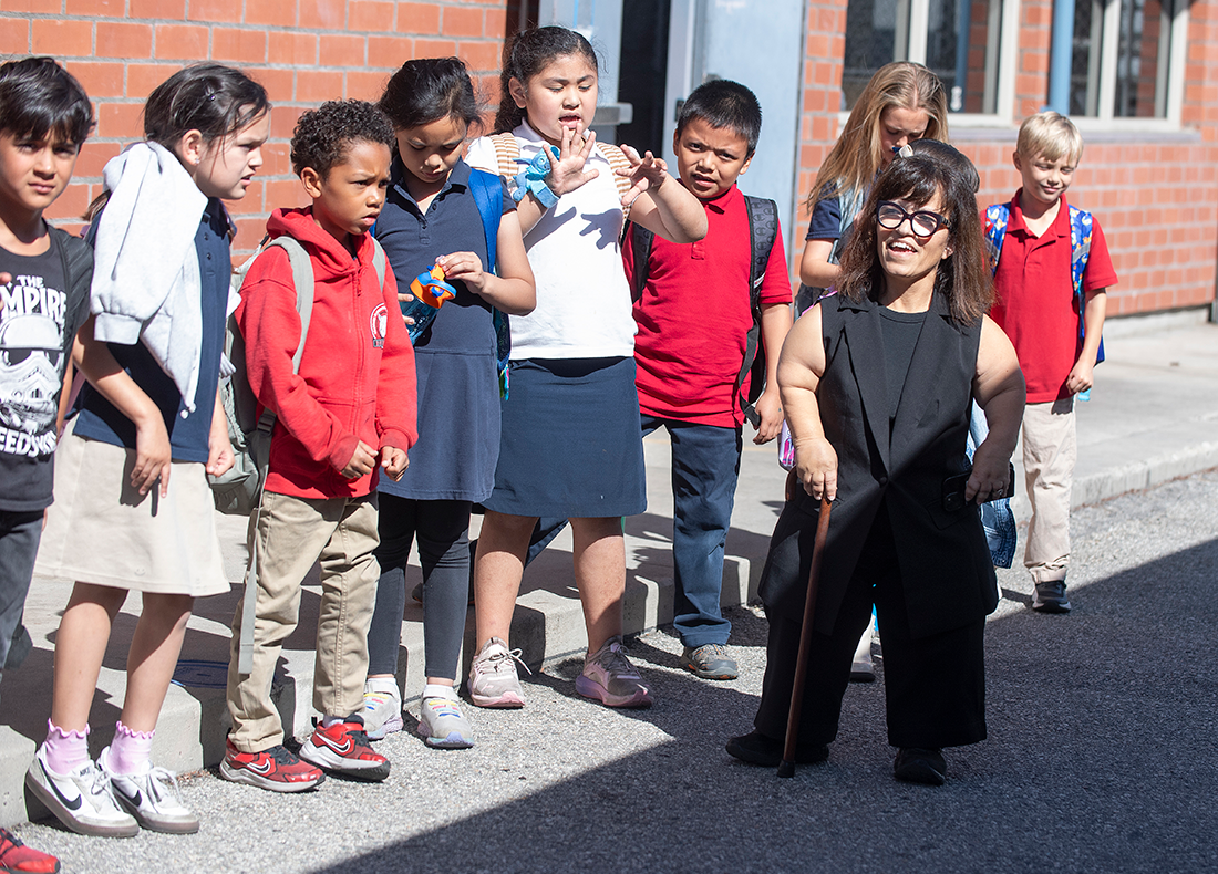 Heather and her classroom are lined up outdoors.