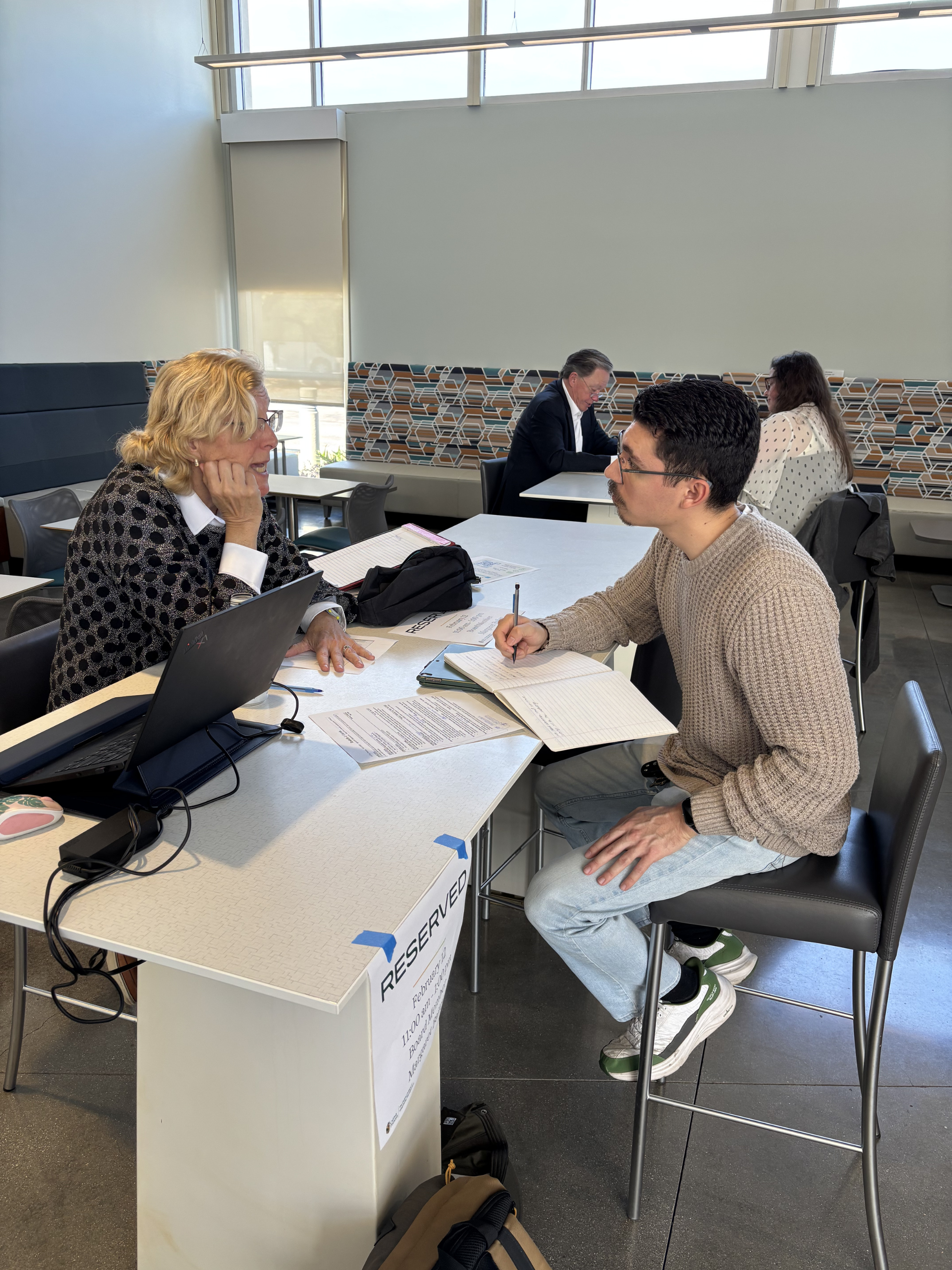 Male student consults a career fair expo representative.