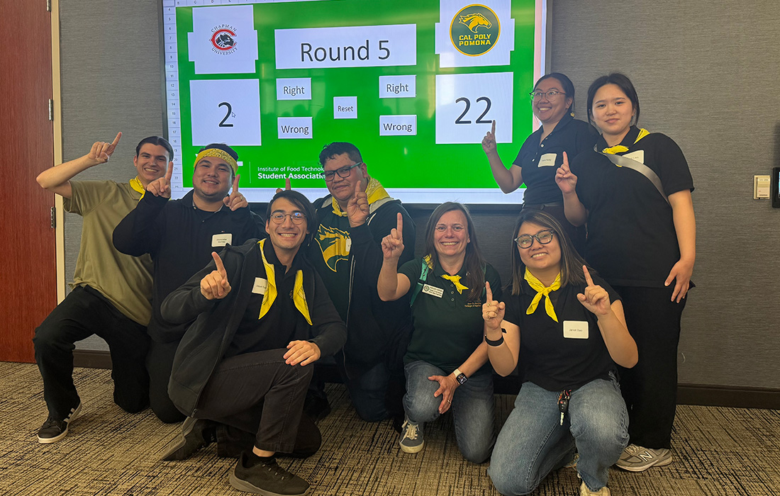 Food and Technology winning team pose for a group photo in front of a screen. 