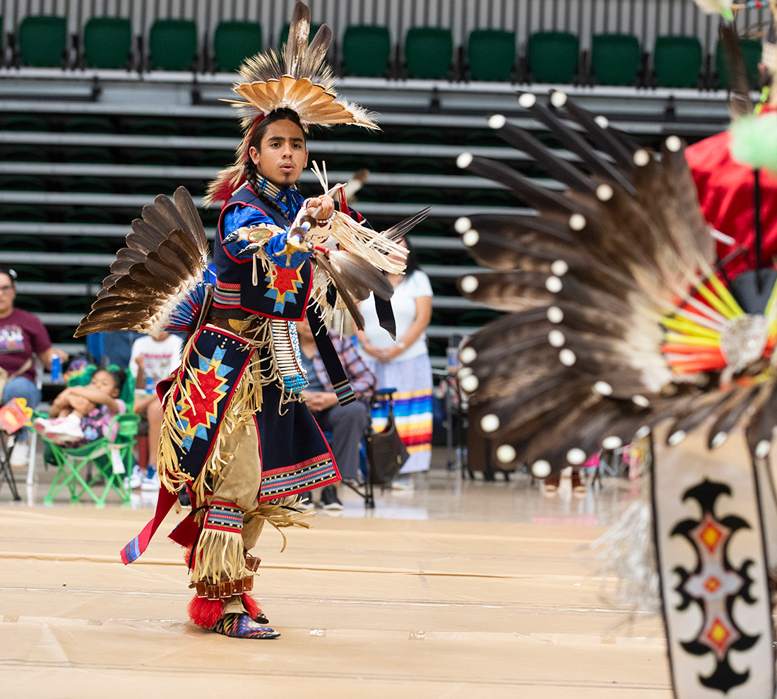 Male Dancer in Native American wardrobe performs during the Powwow
