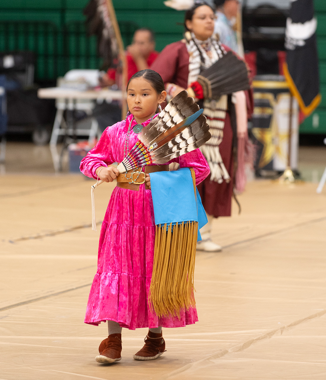 Female Child participates in the Powow wearing pink traditional wardrobe.