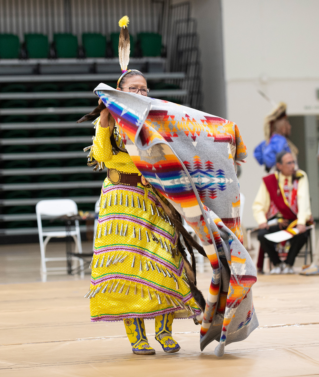Female native american dancer holding a traditional blanket.