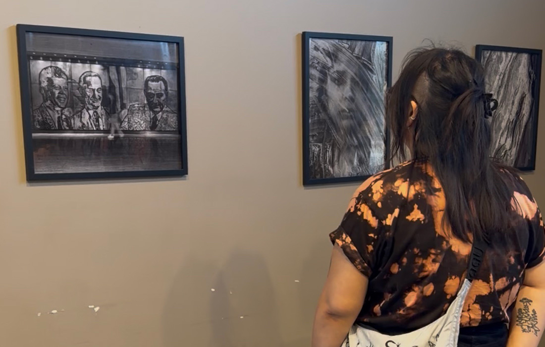 A female patron looks at art on the wall. 