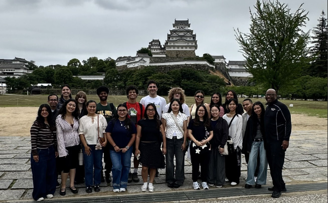 Renford Reese and students pose for a group photo in front of a Japanese templet. 