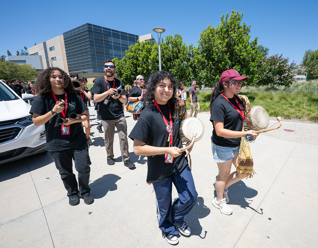 Students walk across campus with drums and sing during CSSSA at CPP.