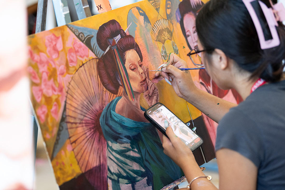 Female student paints a portrait.