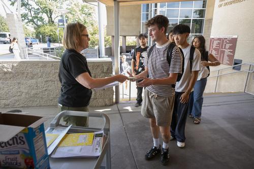professor passing out handouts to students