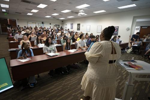 professor speaking in front of the classroom full of students