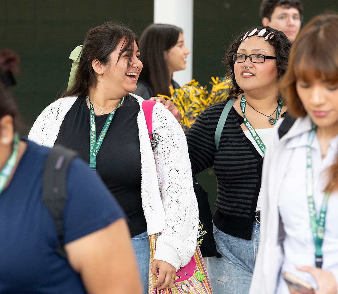 A female student smiles while walking around during Orientation