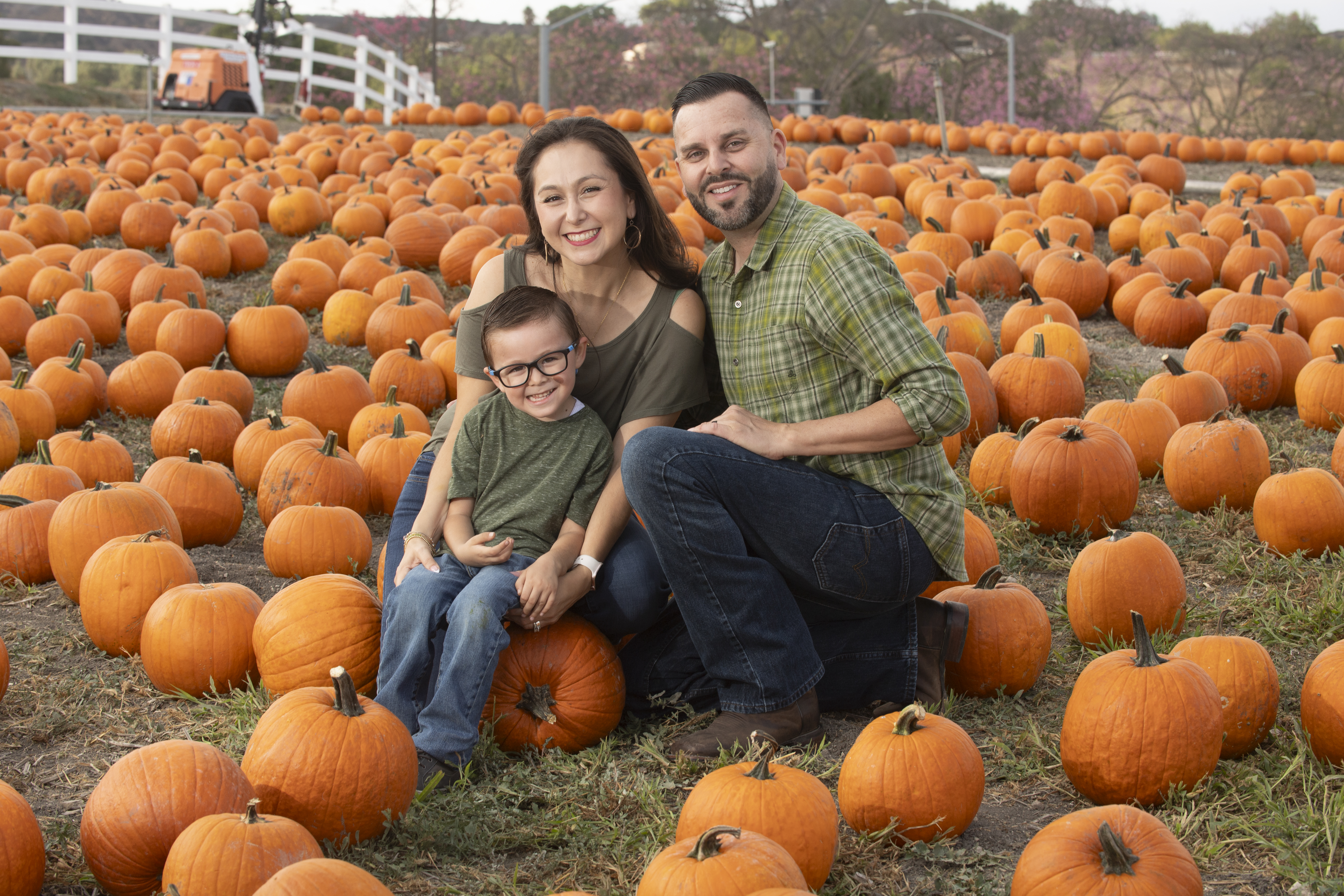 A couple and their son pose for a photo in the pumpkin patch during Pumpkin Fest at Cal Poly Pomona.