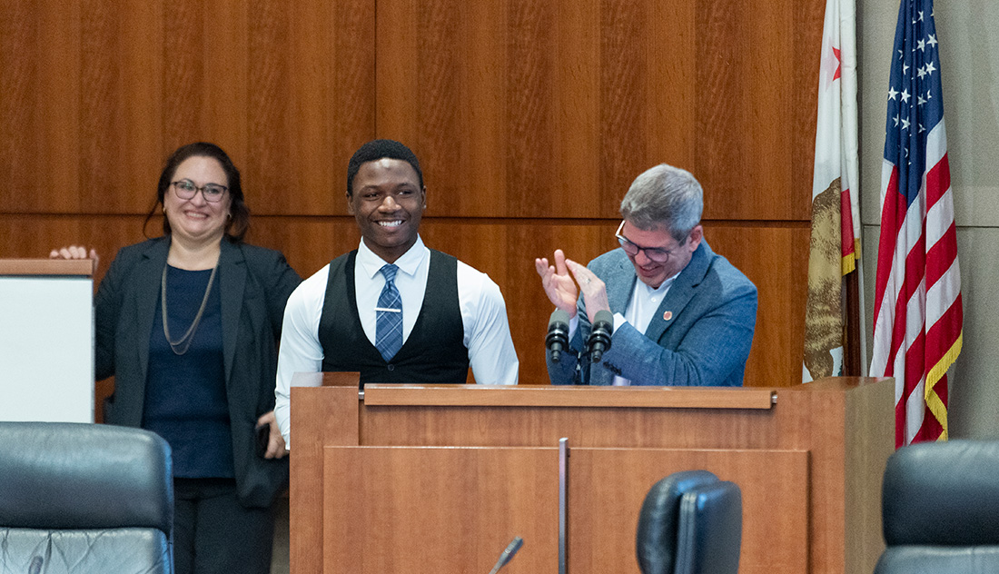 KeJuan Jones stands at the podium to accept his award during the Board of Trustees meeting