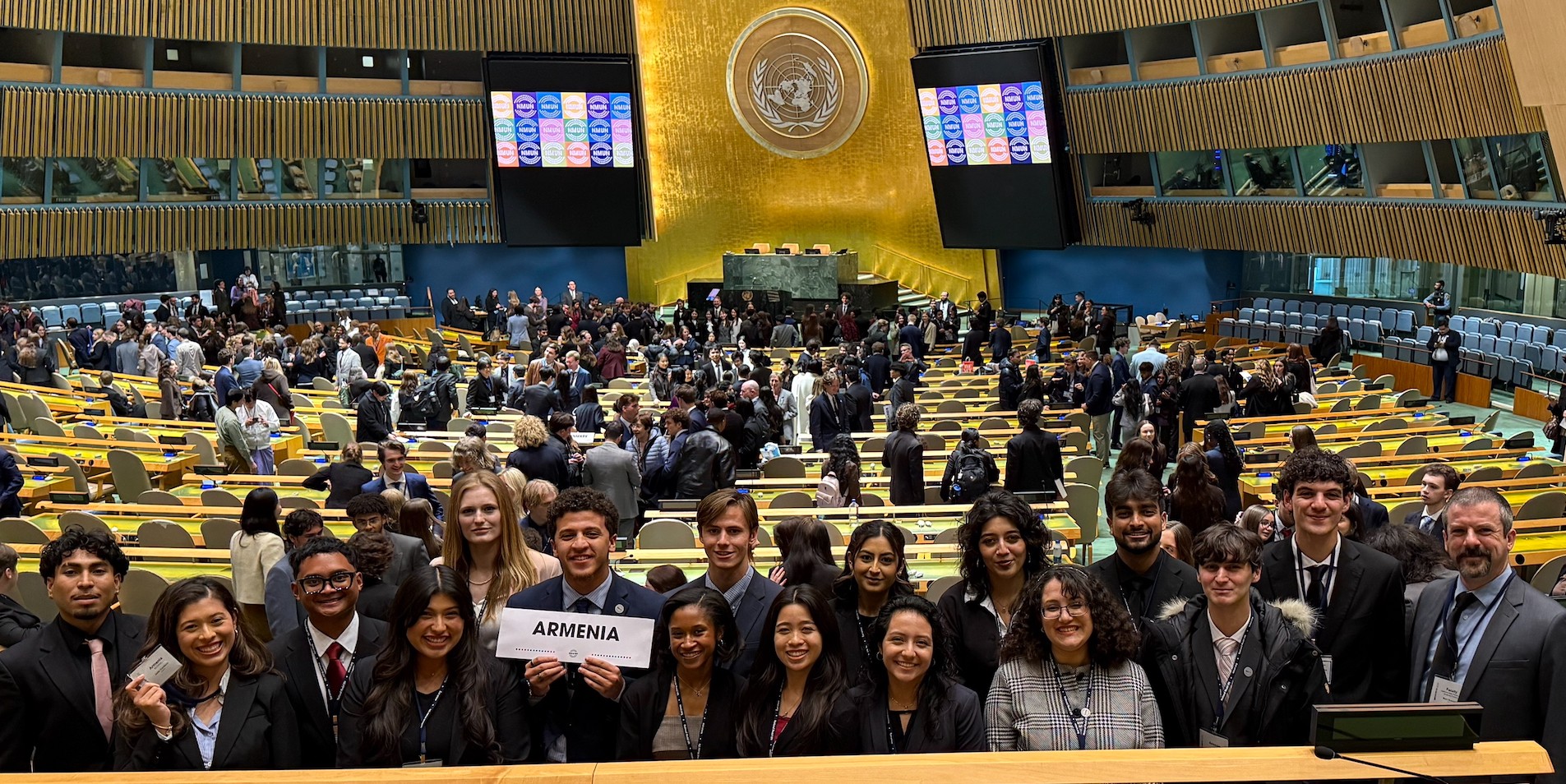 The 16 member Model UN Team holding a card respresenting Armenia at the Conference 