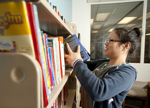 May Mei, a freshman food science major, straightens books on the shelves at the Library Used Bookshop.