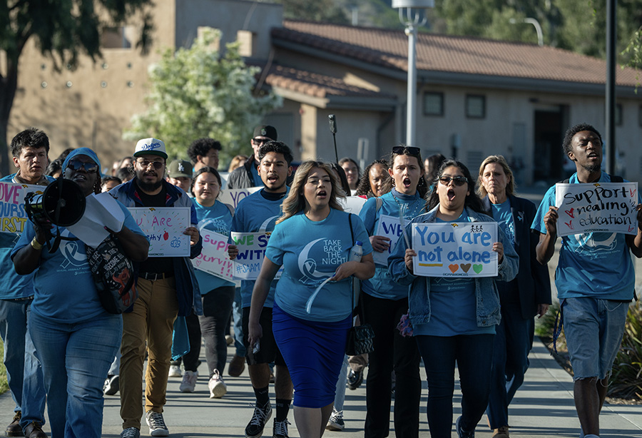 students marching in teal shirts