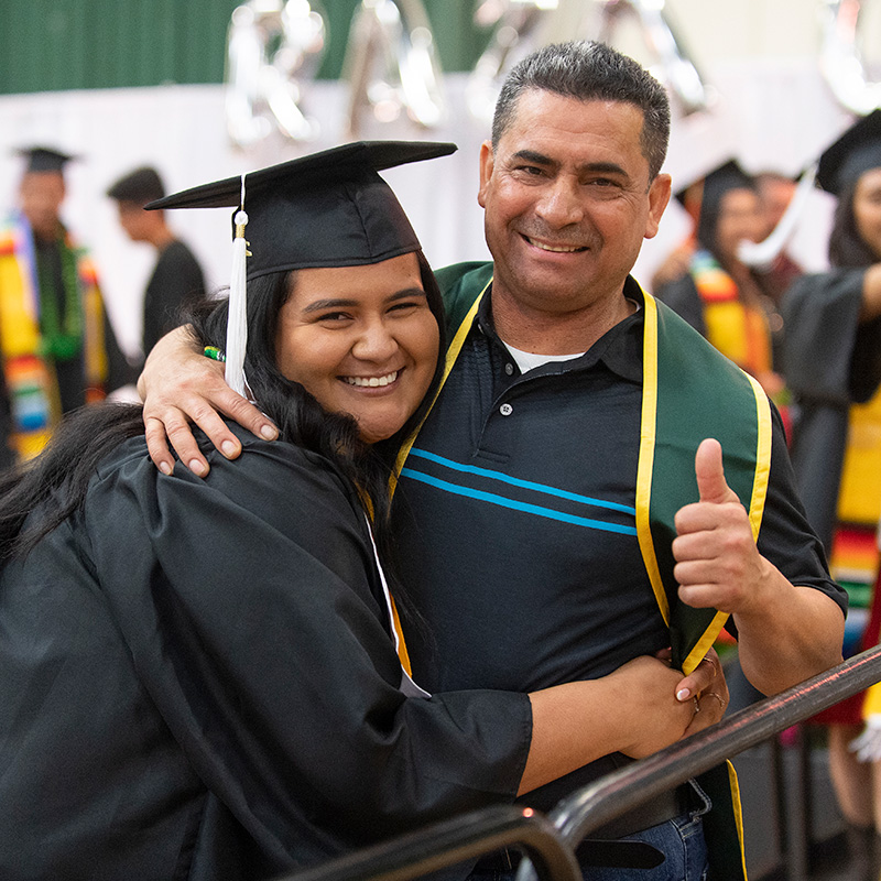 Father hugs his daughter during commencement.