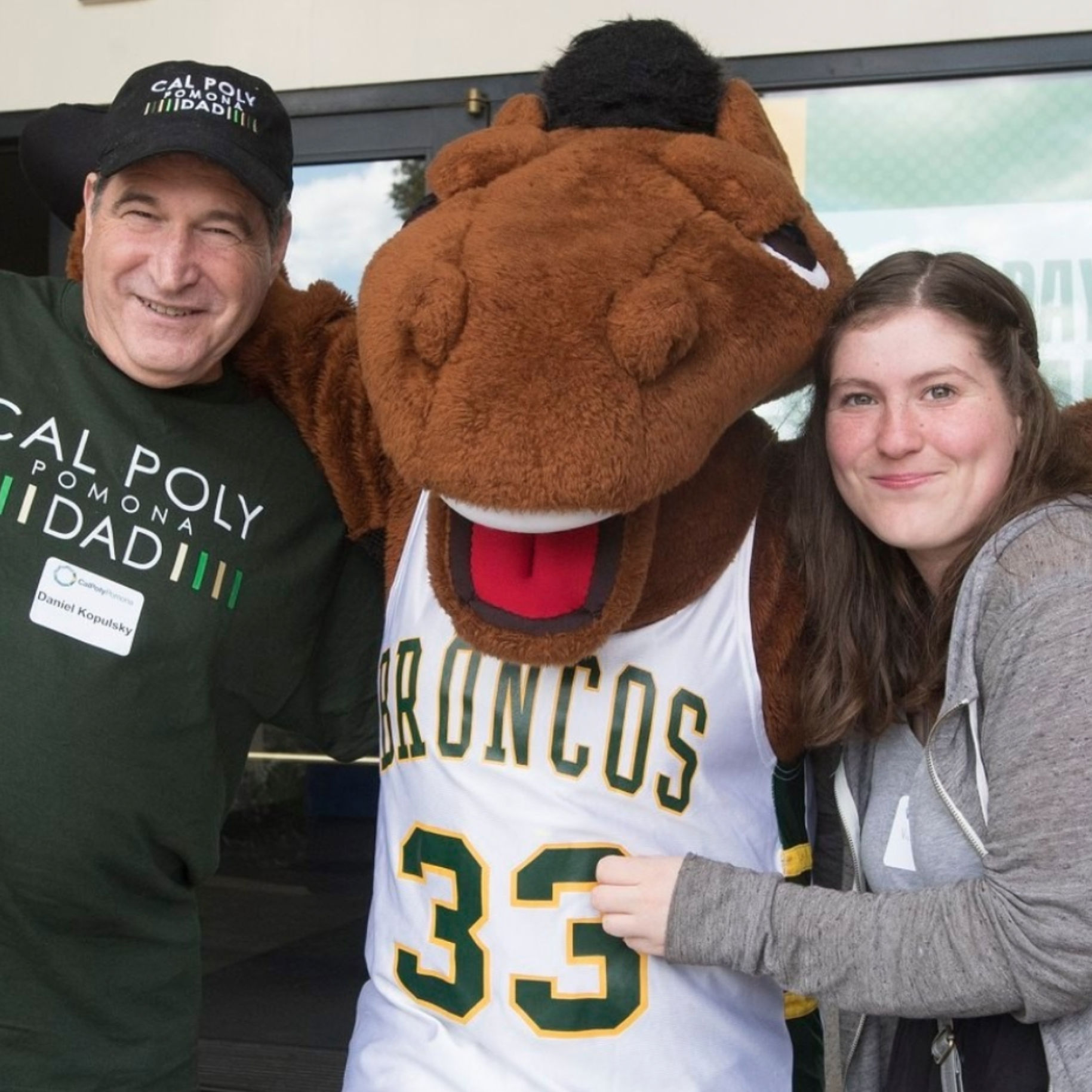 A student posing with their family and billy