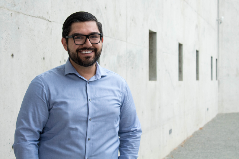 Faculty Director standing in front of a white wall