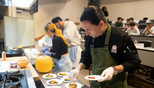 Student working in a kitchen, making plates.