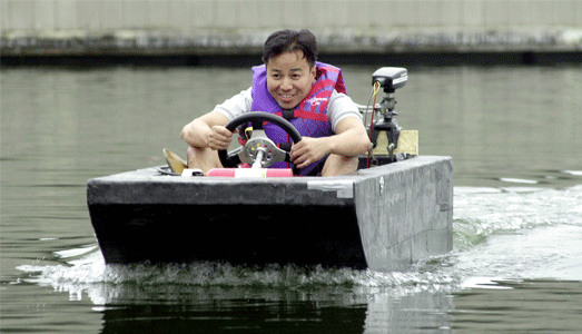 Student sailing his boat in the water.