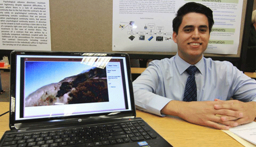 Student smiling next to his presentation.