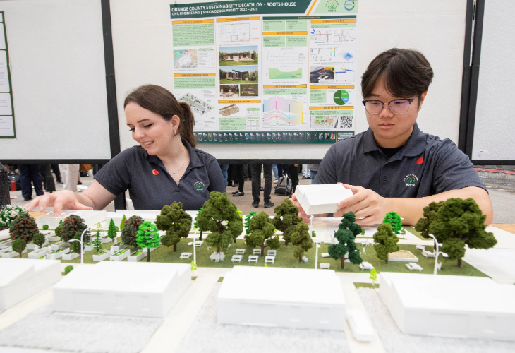 Two students going over a model display.