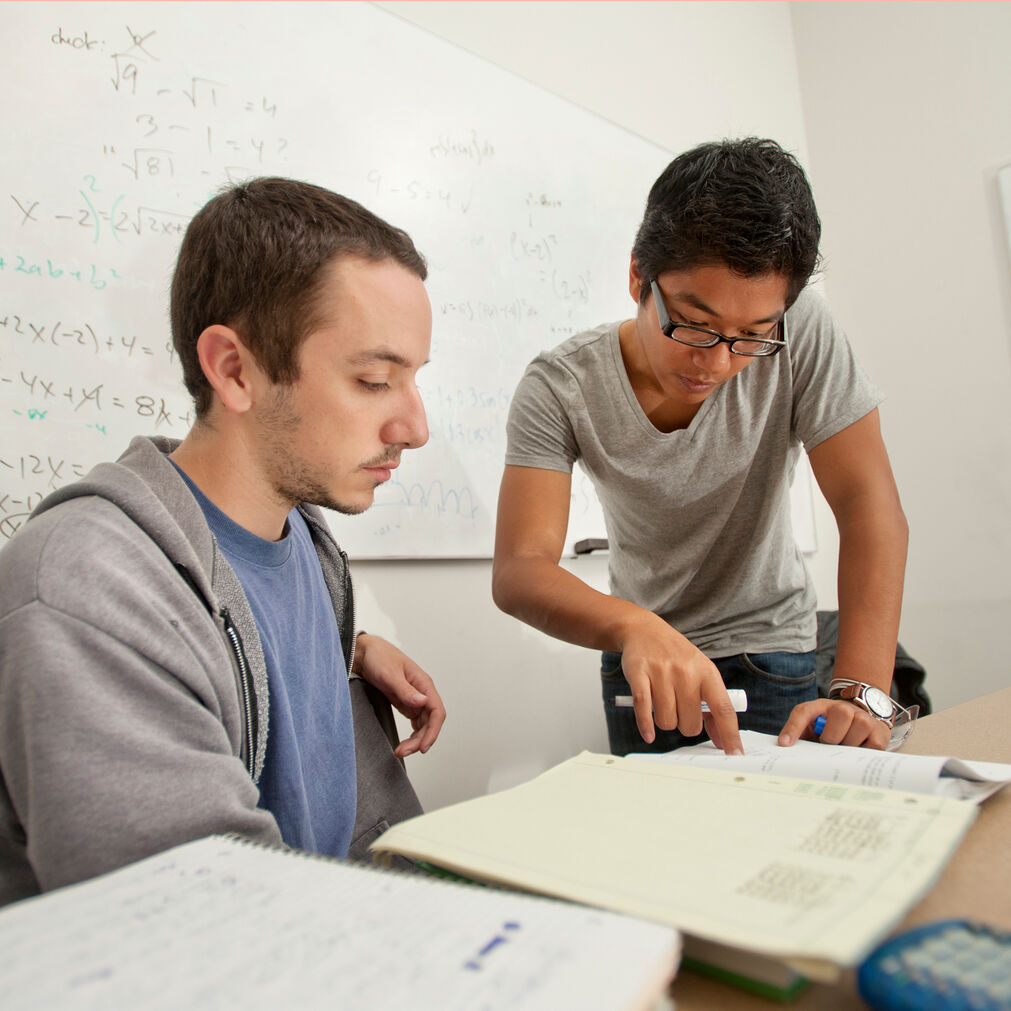 Two students reading a book.