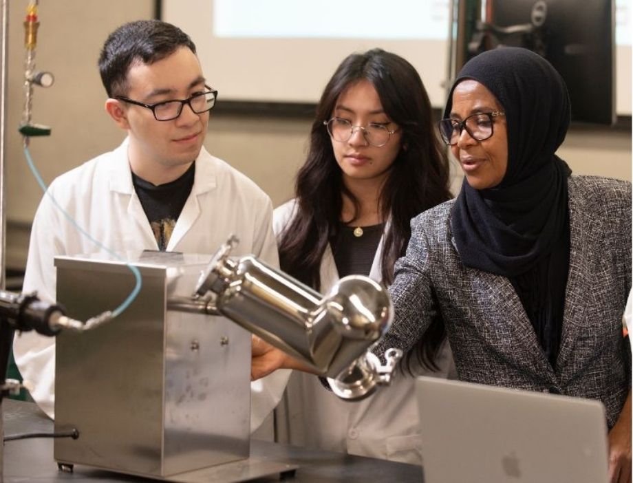 A faculty member and students in a lab.