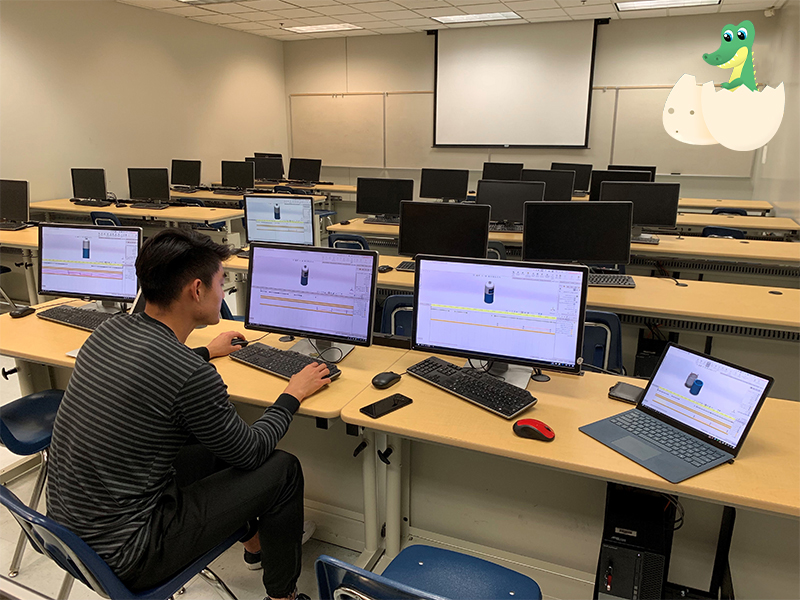 Student sitting alone in a computer lab with the LTD icon on the upper right hand corner