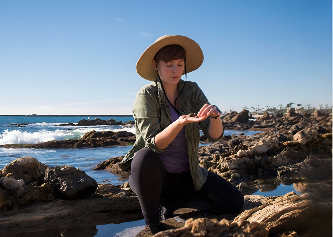 Student conducting research by the ocean.
