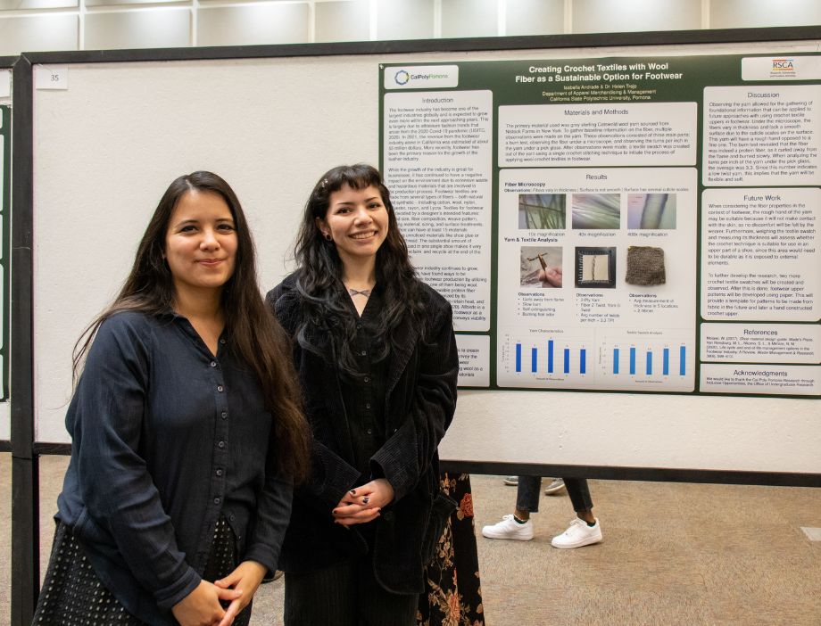Two students in front of their research poster.